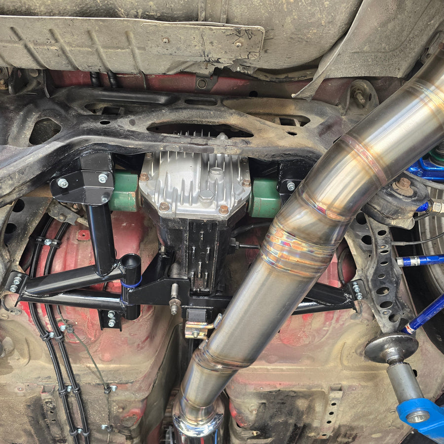 Underbody view of a rear subframe, diff and stainless exhaust on a Vinny Fab build